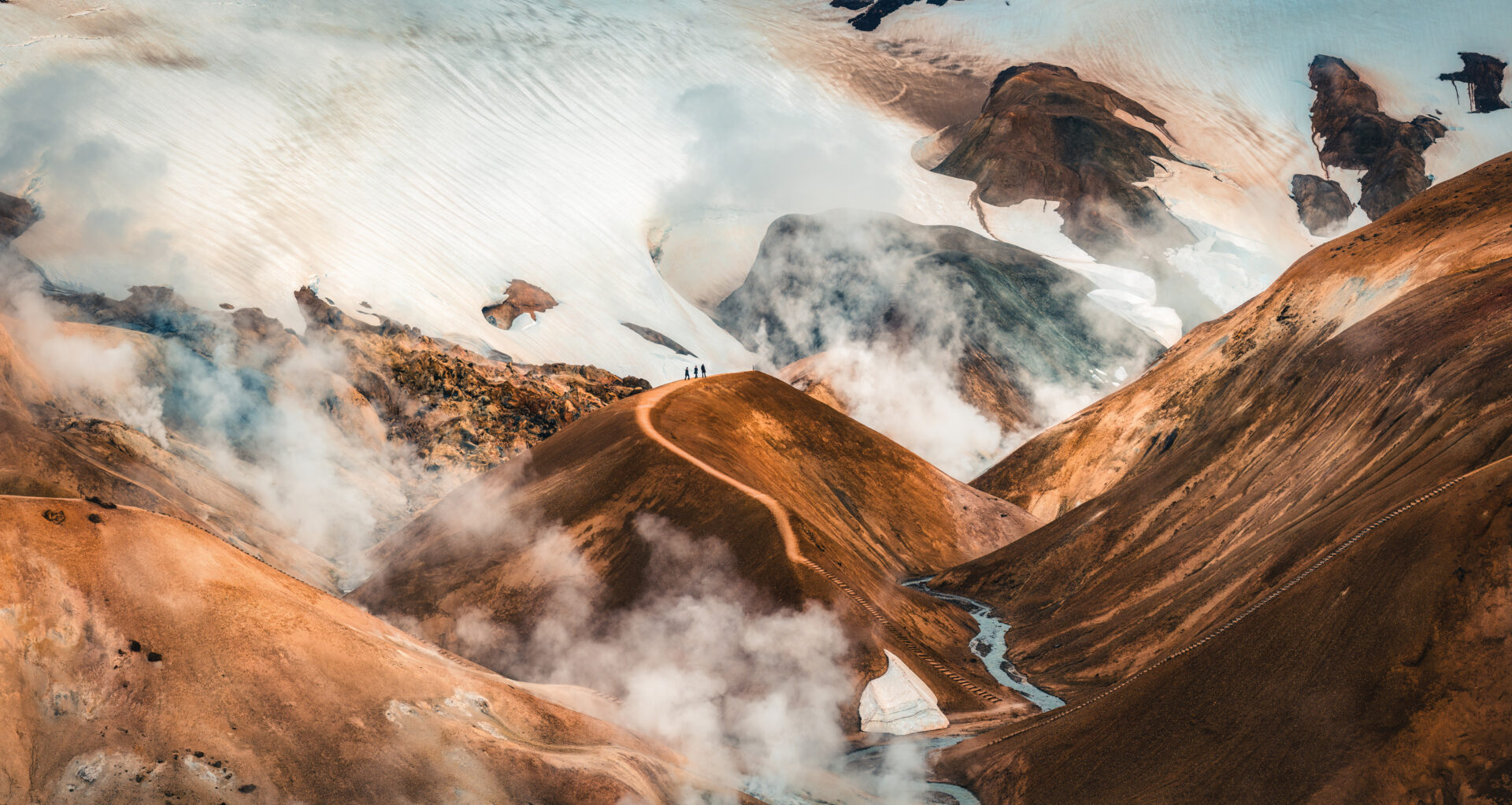 Majestic landscape of Kerlingarfjoll volcanic mountain range with sulfur smoke and tourist hiking on Hveradalir trail in summer at Highlands of Iceland