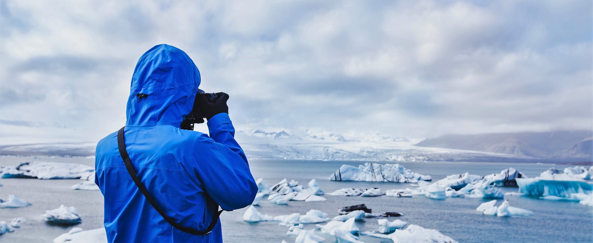 Antarctica Traveler with binoculars watching icebergs