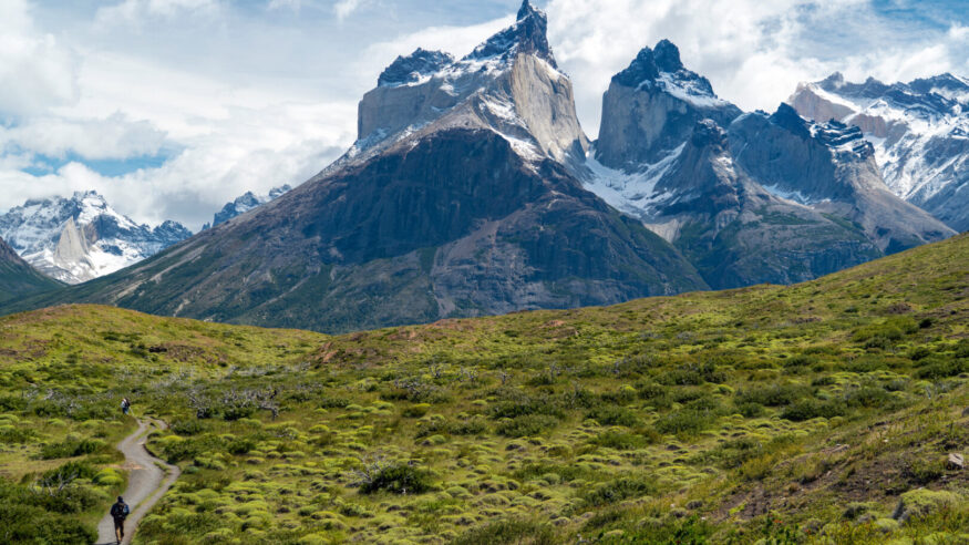 Hiker in Torres del Paine National Park in Chile with the iconic Cuernos del Paine mountains in the background, Patagonia, South America.
