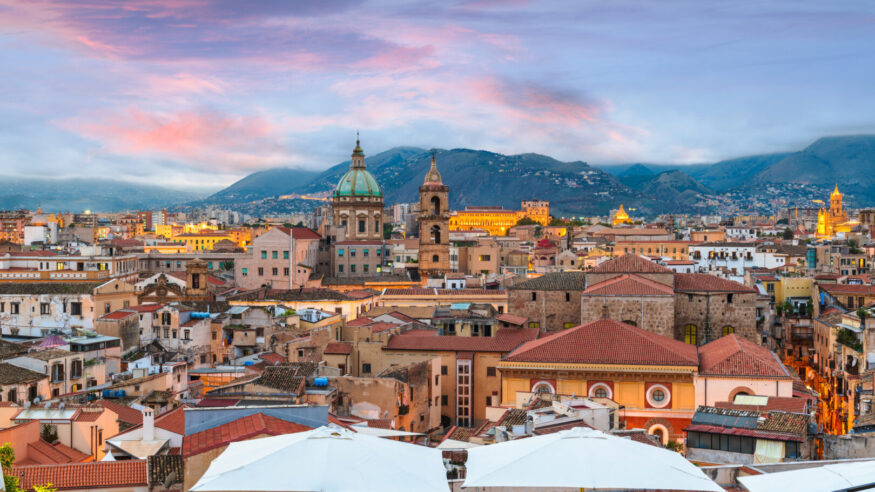 Palermo, Sicily town skyline with landmark towers at dusk.