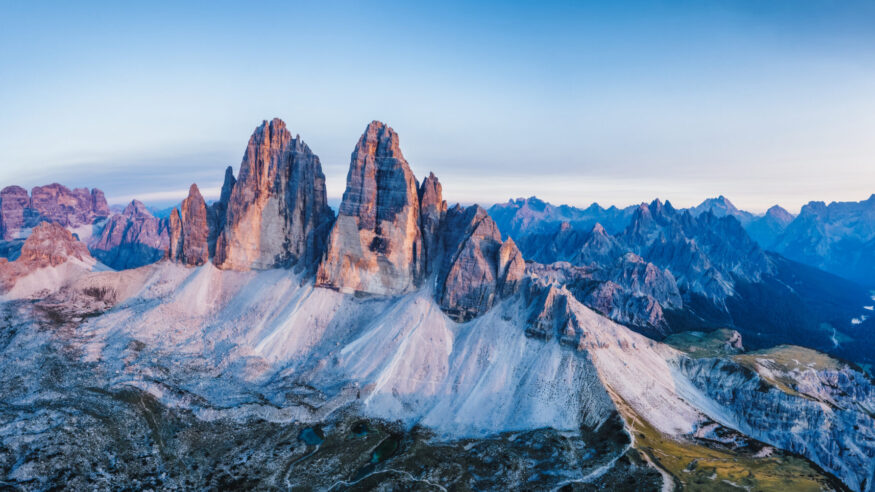 Aerial view of a woman hiker on mountain top enjoying Cadini di Misurina mountain peaks, Italian Alps, Dolomites, Italy, Europe.