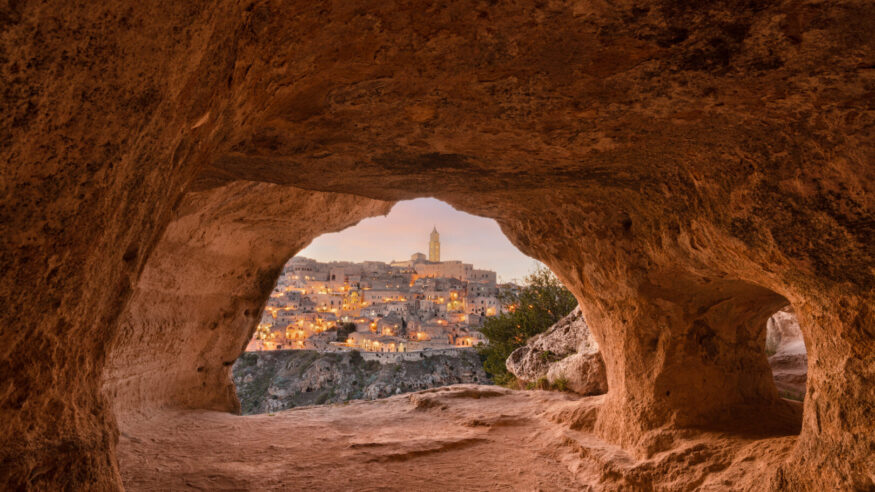 Matera, Italy as seen from within an ancient cave at dusk.