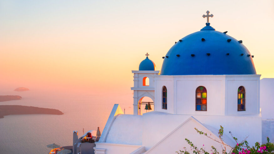 Church with blue dome at sunset on Santorini island, Greece. Summer landscape, sea view